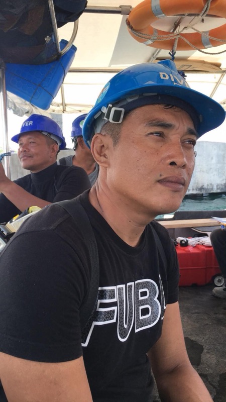 Crew member portrait wearing blue DIVER helmet on boat