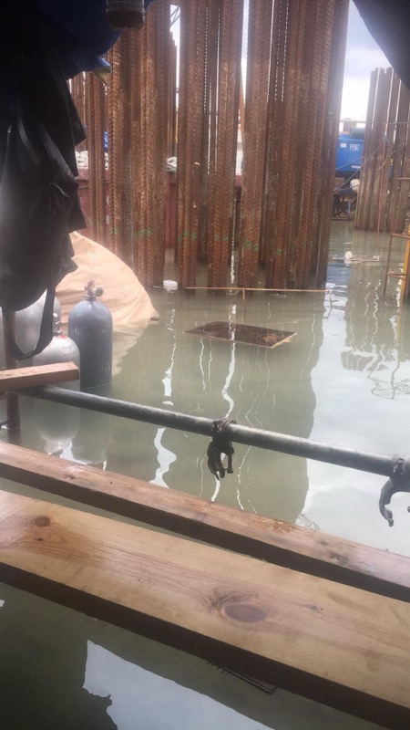 Diver submerging at pier during commercial dive operation