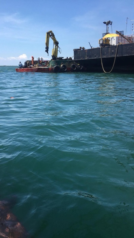 Barge with excavator at marine construction site